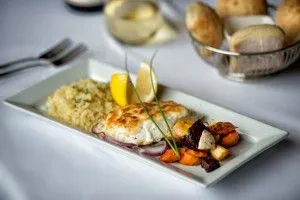 white fish meal with root vegetables and mashed potatoes on a platter with a thyme garnish - Westmark Fairbanks